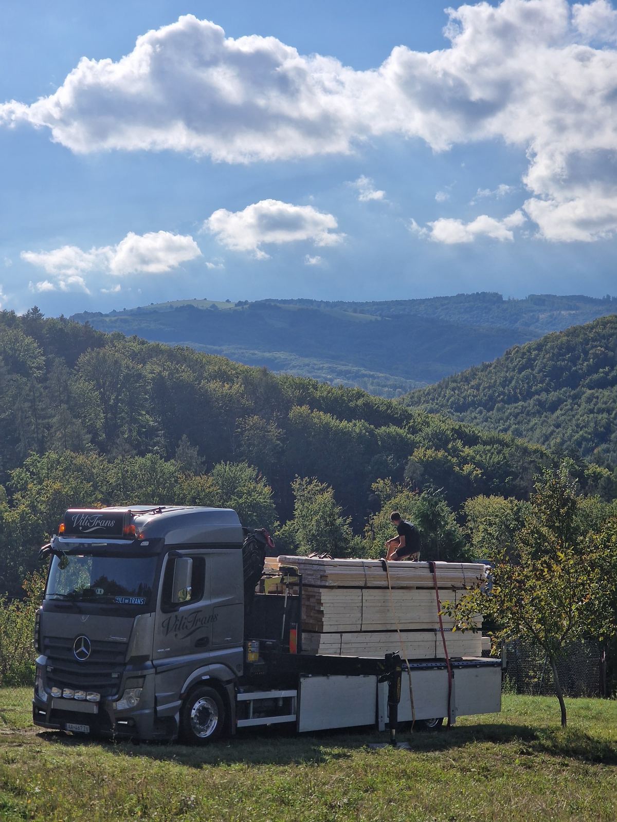Dovoz stavebného materiálu hydraulickou rukou na stavbu